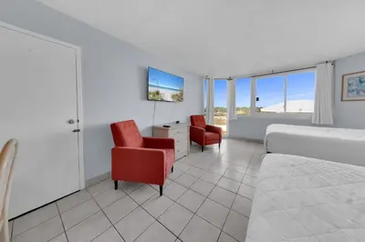 a bedroom with a bed and two chairs and a desk at Top of the Gulf 416 in Panama City Beach