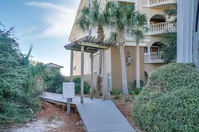 a building with palm trees in front of it at Magnolia Cottages by the Sea by Panhandle Getaways in Seacrest