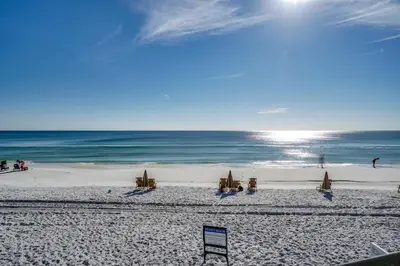 a beach with chairs and umbrellas and the ocean at Magnolia Cottages by the Sea by Panhandle Getaways in Seacrest