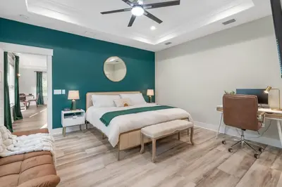 a bedroom with a bed and a blue wall at Emerald-Gem-Inn • Laguna Haven/Beach Home! in Panama City Beach