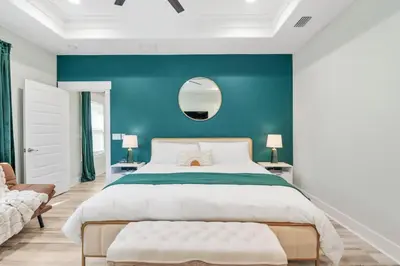 a bedroom with a large bed and a blue wall at Emerald-Gem-Inn • Laguna Haven/Beach Home! in Panama City Beach