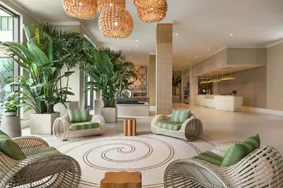 a lobby with chairs and plants in a building at Embassy Suites By Hilton Panama City Beach Resort in Panama City Beach