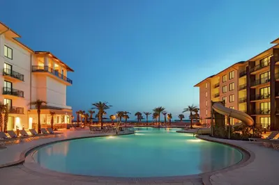 a swimming pool with a slide in a resort at Embassy Suites By Hilton Panama City Beach Resort in Panama City Beach