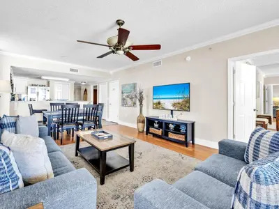a living room with blue couches and a table at Majestic Beach Towers 1-1701 in Panama City Beach