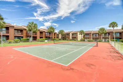 a tennis court in front of a apartment complex at Beach Walk 10C by Sand Seeker Vacations in Panama City Beach