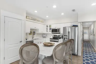 a kitchen with a table and chairs and a refrigerator at Villas at Seacrest by Panhandle Getaways in Seacrest
