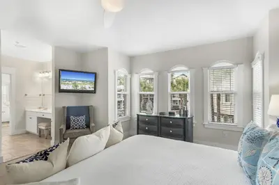 a bedroom with a bed and a desk and windows at Villas at Seacrest by Panhandle Getaways in Seacrest