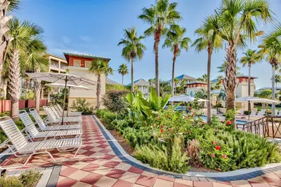 a resort patio with chairs and palm trees at Villas at Seacrest by Panhandle Getaways in Seacrest