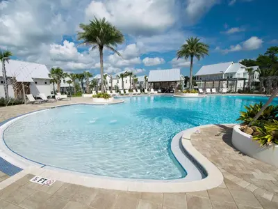 a large swimming pool in a resort with palm trees at Prominence North #89C - Sun Times in Watersound Beach