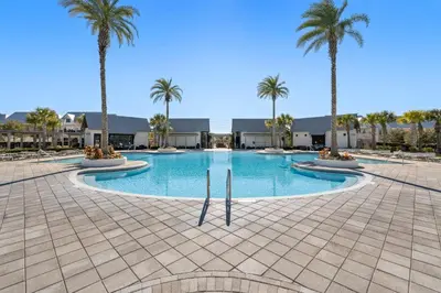 a swimming pool with palm trees in a resort at Prominence North #89C - Sun Times in Watersound Beach