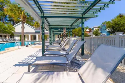 a row of chaise lounges next to a pool at Prominence North #89C - Sun Times in Watersound Beach