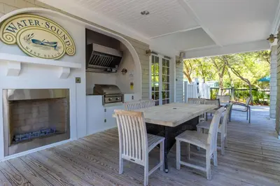 a porch with a table and chairs and a fireplace at Prominence North #89C - Sun Times in Watersound Beach