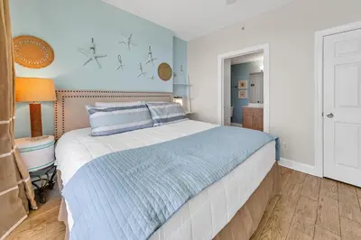 a bedroom with a bed with blue and white sheets at Emerald Isle 1201 in Panama City Beach
