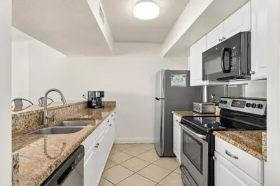 a kitchen with a sink and a refrigerator at Enjoy A Birds Eye View at Panama City Beach in Panama City Beach