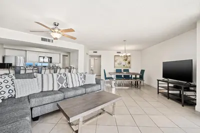 a living room with a couch and a flat screen tv at Enjoy A Birds Eye View at Panama City Beach in Panama City Beach