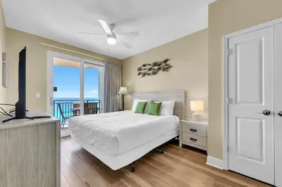 a bedroom with a bed and a view of the ocean at Sterling Breeze 1204 in Panama City Beach