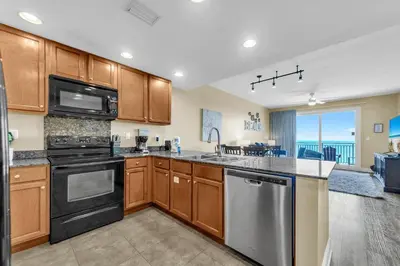 a kitchen with stainless steel appliances and a large window at Sterling Breeze 1204 in Panama City Beach