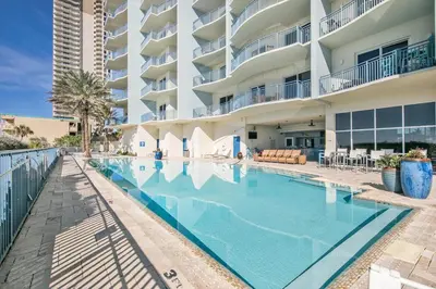 a swimming pool in front of a large apartment building at Sterling Breeze 1204 in Panama City Beach