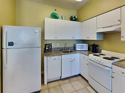 a kitchen with white appliances and a white refrigerator at Shores of Panama #1406 in Panama City Beach