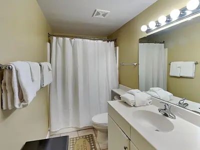 a bathroom with a sink and a toilet and a mirror at Shores of Panama #1406 in Panama City Beach