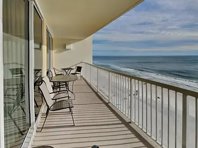 a balcony with chairs and a table and the ocean at Majestic Beach Towers I #1004 in Panama City Beach
