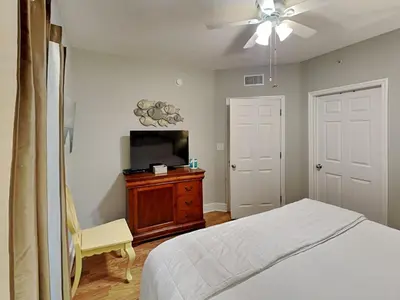 a bedroom with a bed and a flat screen tv at Majestic Beach Towers I #1004 in Panama City Beach