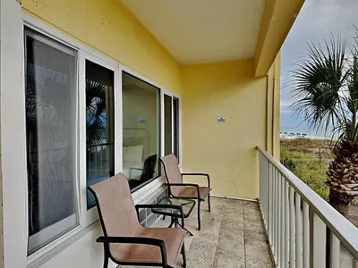 a balcony with three chairs and a window at Continental 206 in Panama City Beach