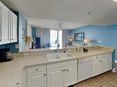 a kitchen with a white sink and a blue wall at Majestic Beach Towers I #1015 in Panama City Beach