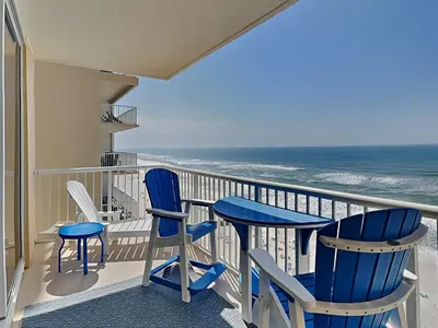 a balcony with blue chairs and the ocean at Majestic Beach Towers I #1015 in Panama City Beach