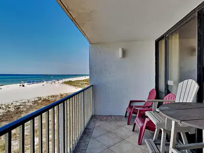 a balcony with a table and chairs and the beach at Edgewater Windward #204 in Panama City Beach