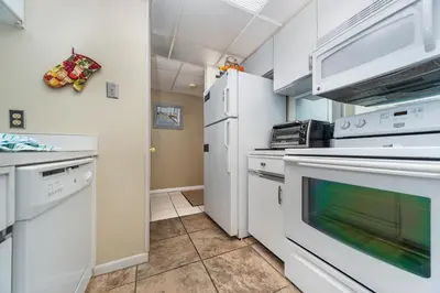 a kitchen with white appliances and white cabinets at Edgewater Windward #204 in Panama City Beach