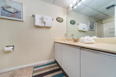 a bathroom with a sink and a mirror at Edgewater Windward #204 in Panama City Beach