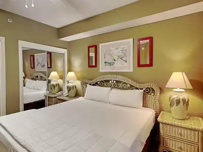 a bedroom with a large white bed and a mirror at Majestic Beach Towers I #1414 in Panama City Beach