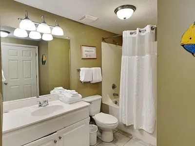 a bathroom with a sink and a toilet and a mirror at Majestic Beach Towers I #1414 in Panama City Beach