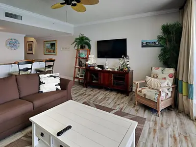 a living room with a couch and a tv at Majestic Beach Towers I #1505 in Panama City Beach