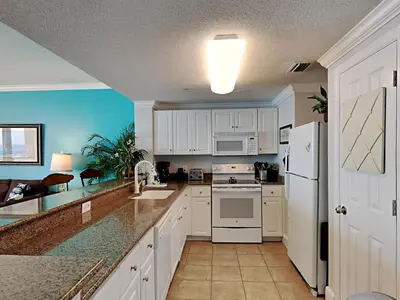 a kitchen with white cabinets and a white refrigerator at Majestic Beach Towers I #1505 in Panama City Beach