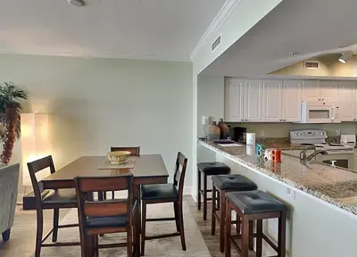 a kitchen with a table and chairs and a counter at Emerald Beach #1531 in Panama City Beach