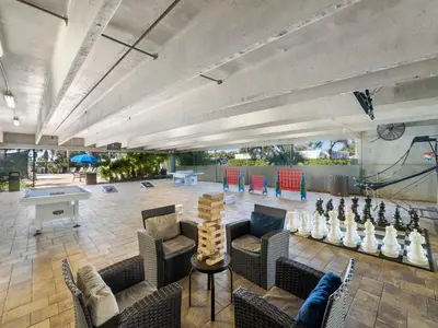a large room with couches and a ping pong table at Emerald Beach #1531 in Panama City Beach