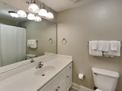 a bathroom with a sink and a toilet and a mirror at Majestic Beach Towers I #311 in Panama City Beach