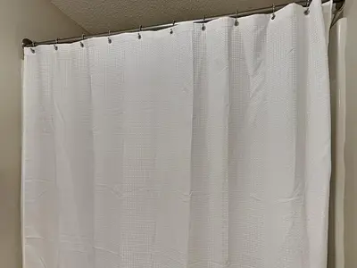 a white shower curtain hanging from a shower rod at Majestic Beach Towers I #311 in Panama City Beach