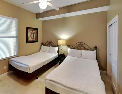 a bedroom with two beds and a ceiling fan at Grandview East #1305 in Panama City Beach