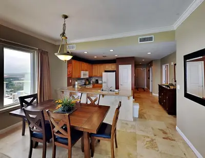 a dining room and kitchen with a table and chairs at Grandview East #1305 in Panama City Beach