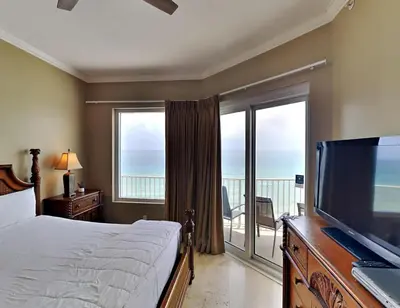 a bedroom with a bed and a flat screen tv at Grandview East #1305 in Panama City Beach