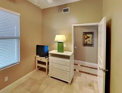 a room with a television and a table with a lamp at Grandview East #1305 in Panama City Beach