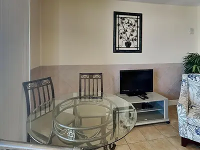 a glass table with two chairs and a television at Majestic Beach Towers I #913 in Panama City Beach