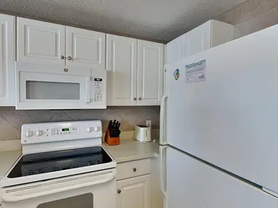 a kitchen with white cabinets and a white refrigerator at Majestic Beach Towers I #913 in Panama City Beach