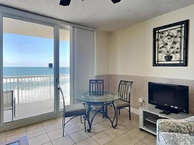 a living room with a glass table and a television at Majestic Beach Towers I #913 in Panama City Beach