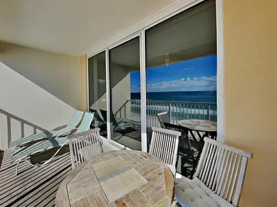 a balcony with a table and chairs and a view of the ocean at Majestic Beach Towers II #707 in Panama City Beach