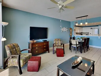 a living room with a flat screen tv and a table at Majestic Beach Towers II #707 in Panama City Beach