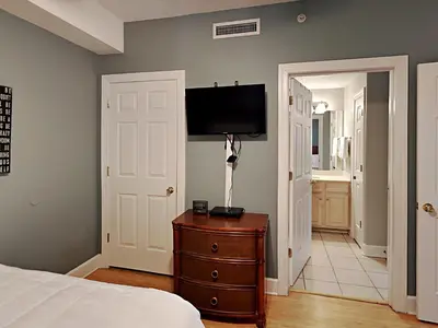 a bedroom with a bed and a television on a wall at Twin Palms #1805A in Panama City Beach
